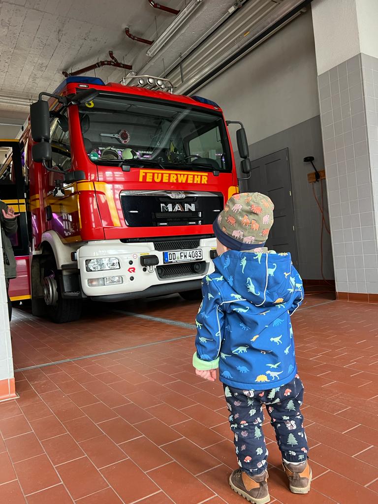 Kleinkind vor Feuerwehrfahrzeug